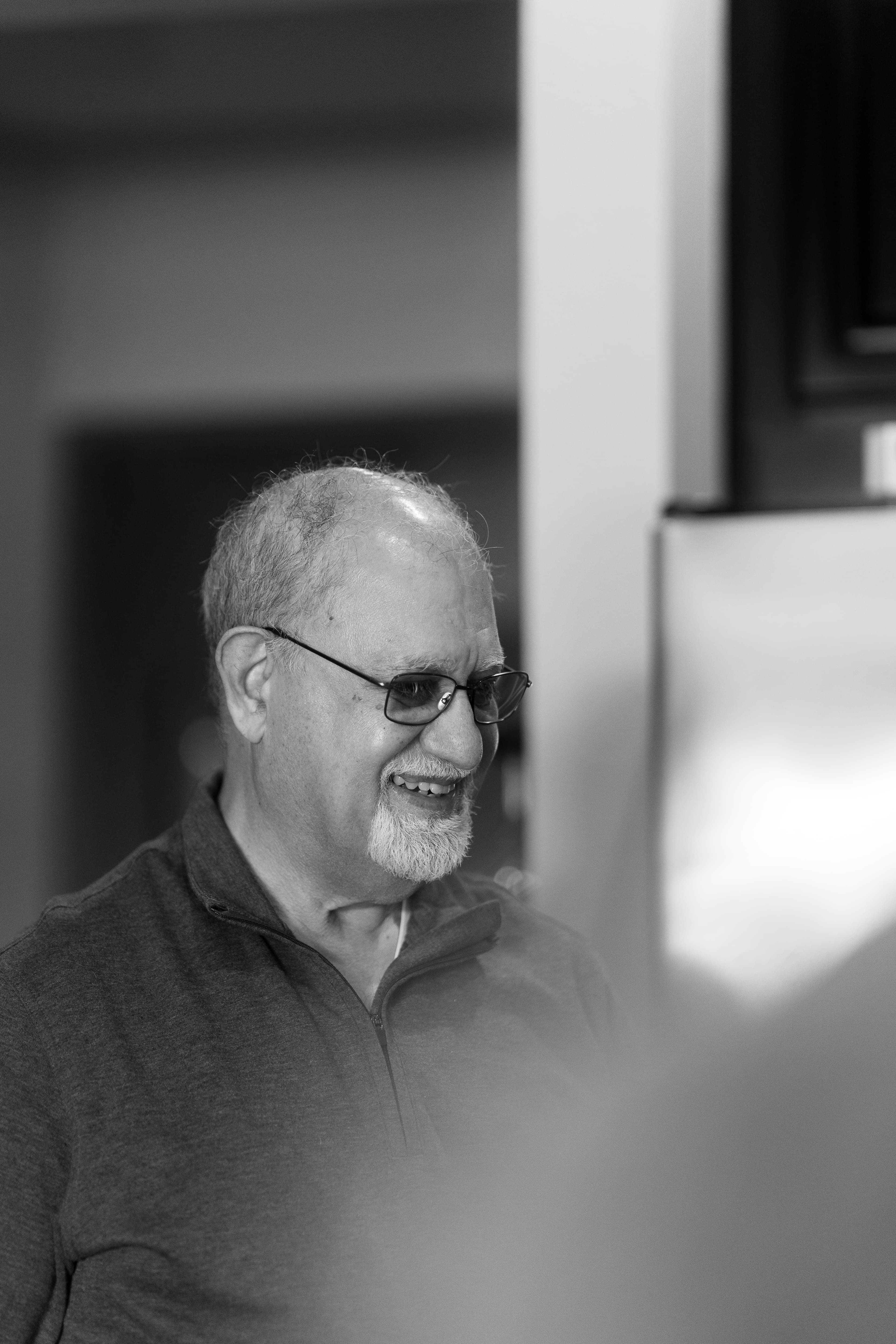 Dr. Khanna smiling and talking to the patient's owner. Photo in black and white.