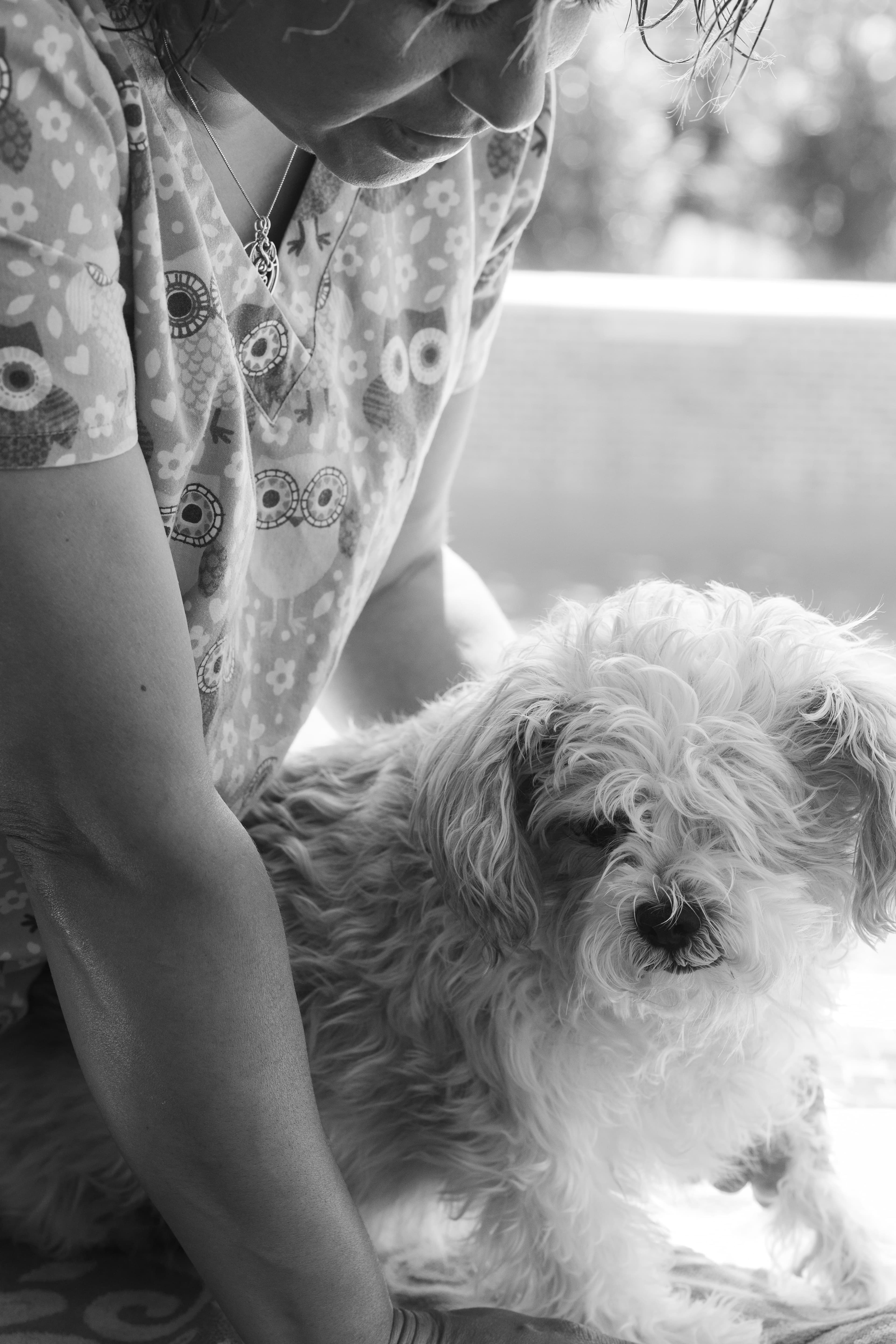 Gia looks and talks to the puppy and is supportive while the puppy awaits the doctor's visit. Photo in black and white.