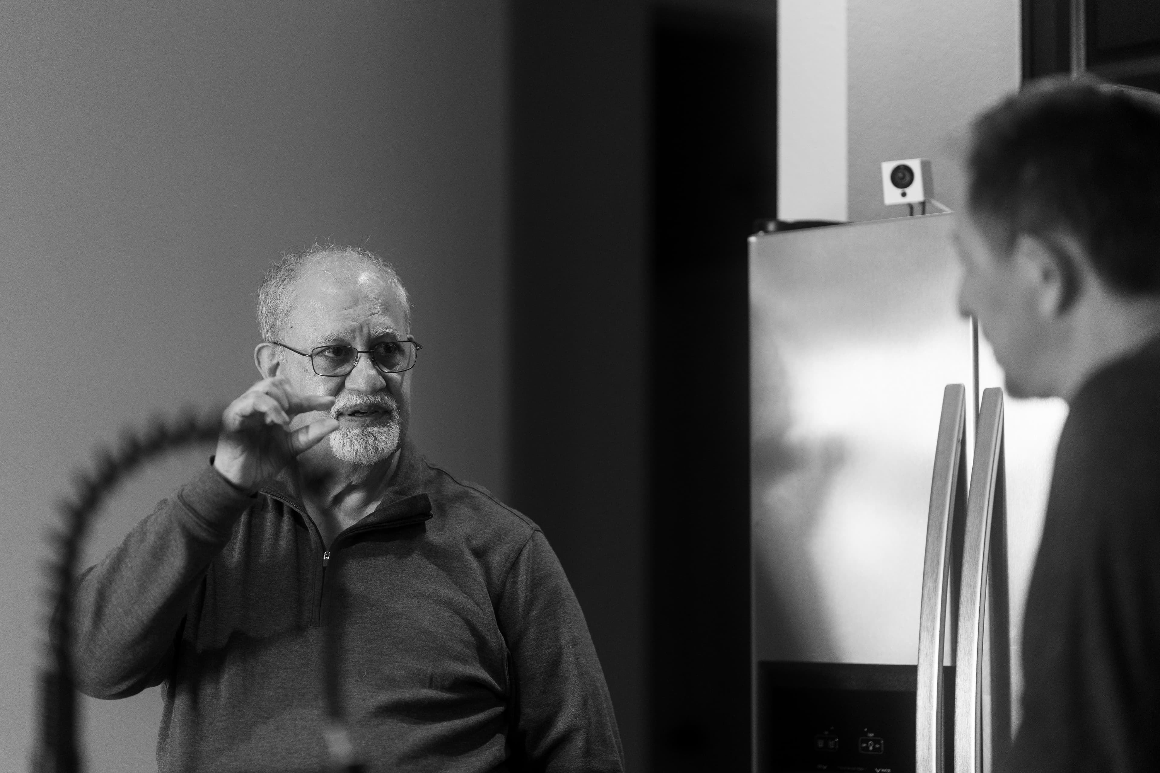 Dr. Khanna explaining to the owner how the test will be run and how much blood is required. Photo in black and white.